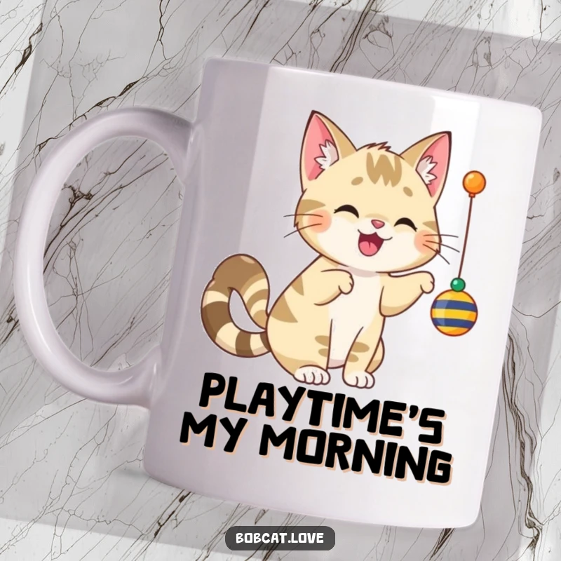 Funny, cheerful bobcat with a wagging tail playfully batting at a dangling toy, featured on a ceramic mug.
